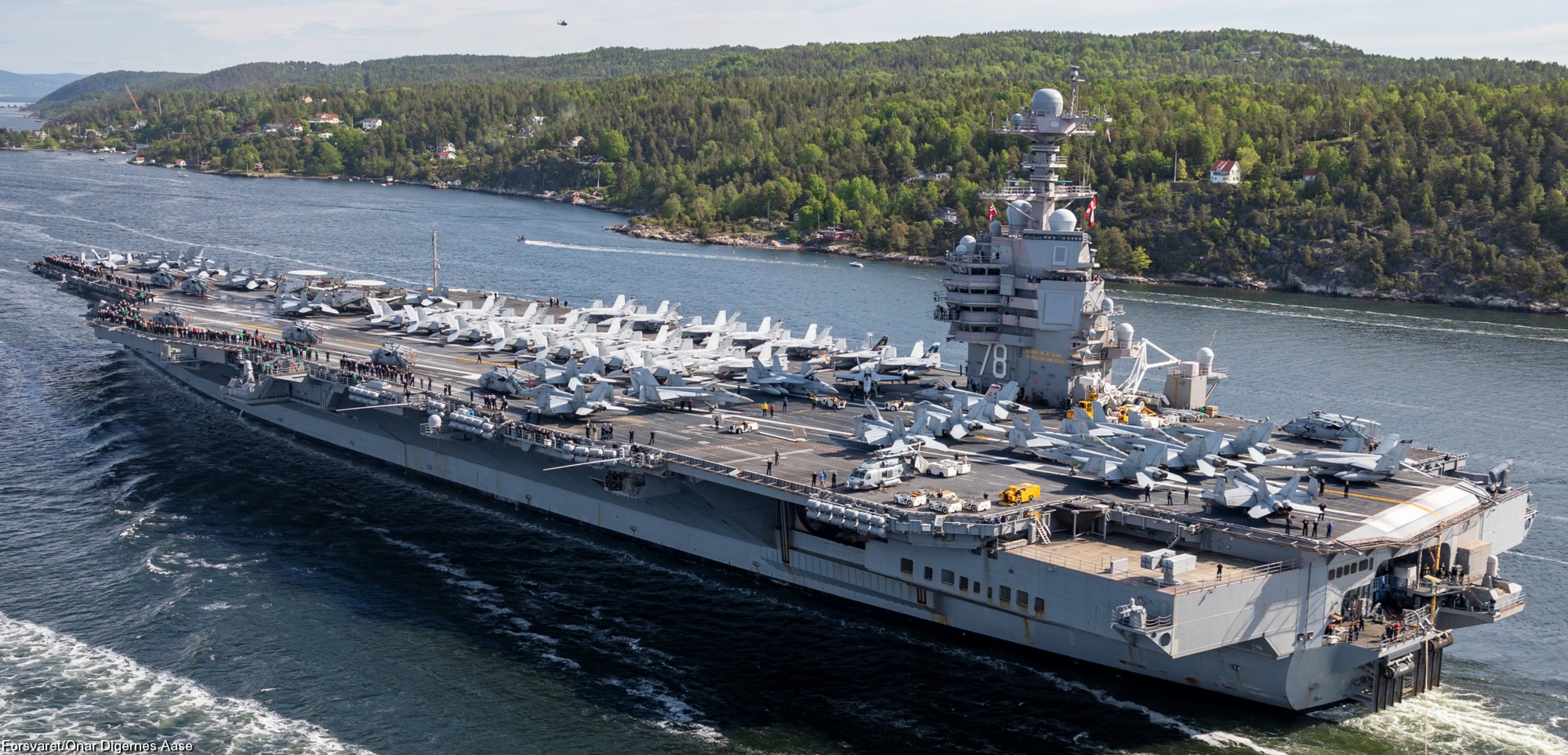 USS Gerald R. Ford underway during pre-deployment training exercises, with aircraft on deck and crew members preparing for launch operations
